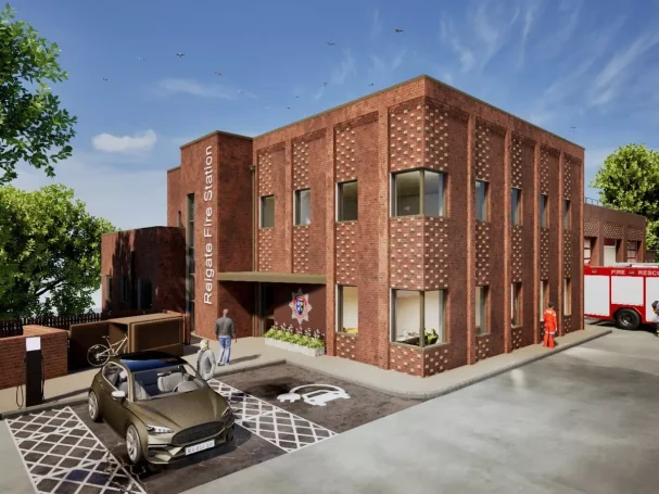 Reigate Fire Station Modern brick building with large windows, parked car, and emergency vehicle outside.
