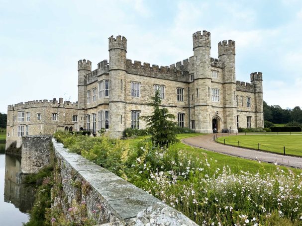 Leeds Castle Historic stone castle with multiple towers, surrounded by greenery and a moat.